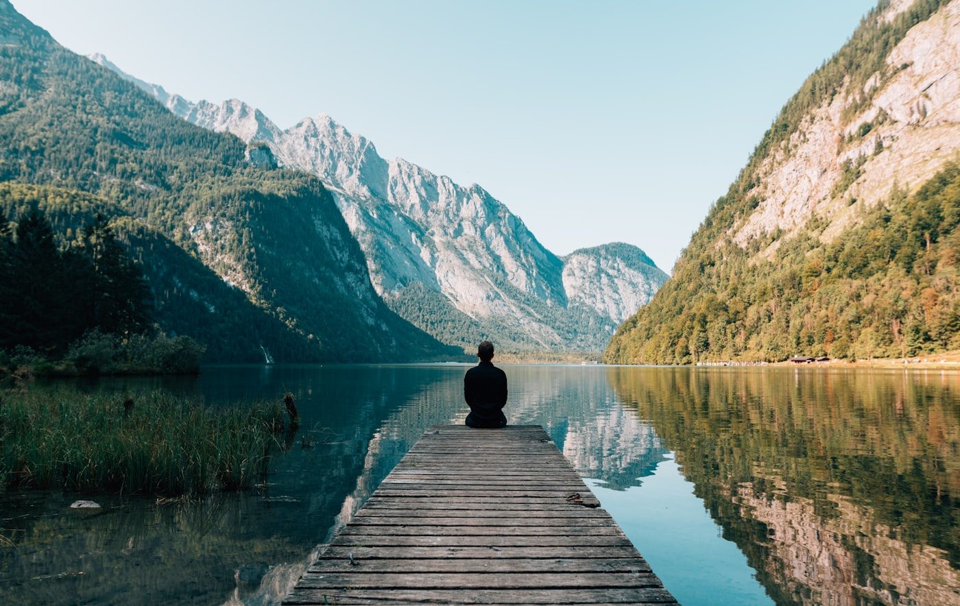 Person sitting alone looking out over the mountains